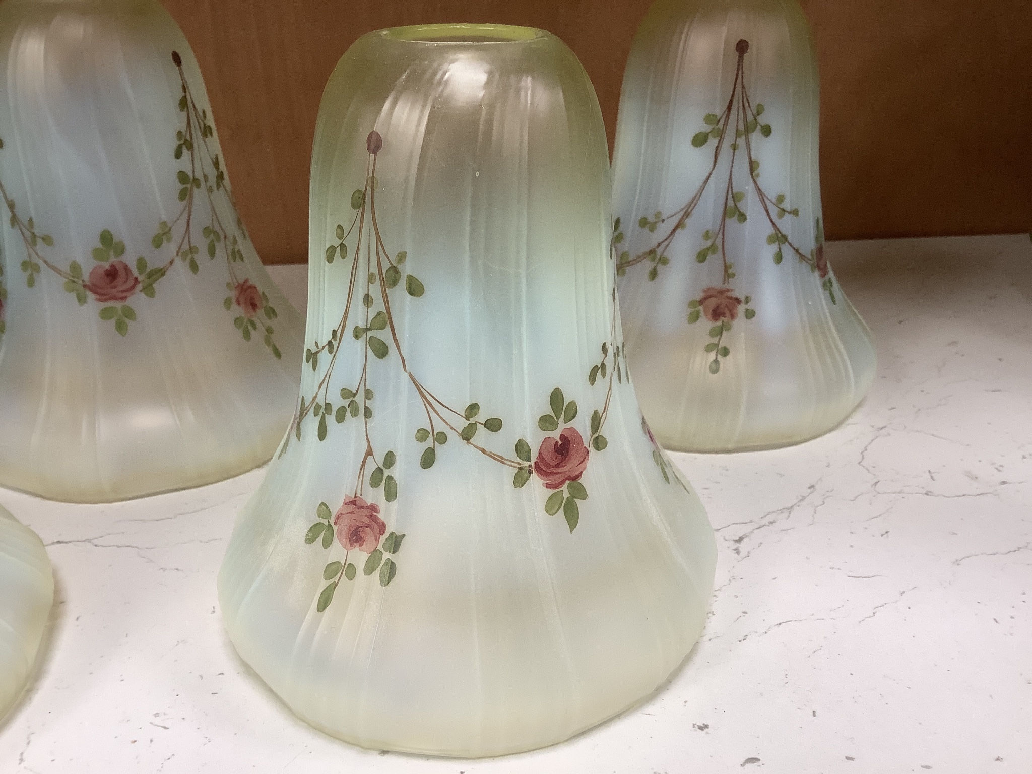 A set of four enamelled vaseline glass shades and a striped shade.